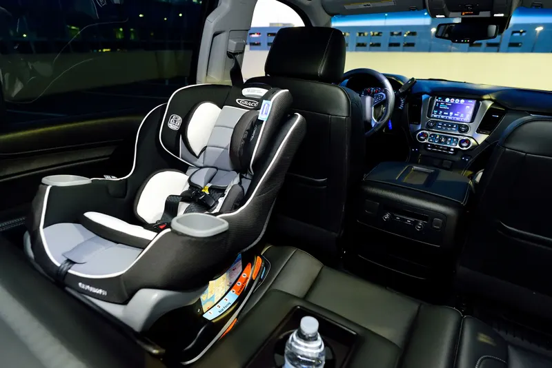 Eltern installieren eine Babyschale im Auto