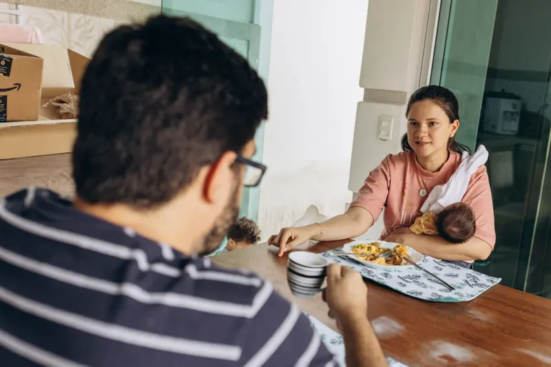 Frischgebackene Eltern mit ihrem Baby und einer Mahlzeit als praktische Unterstützung
