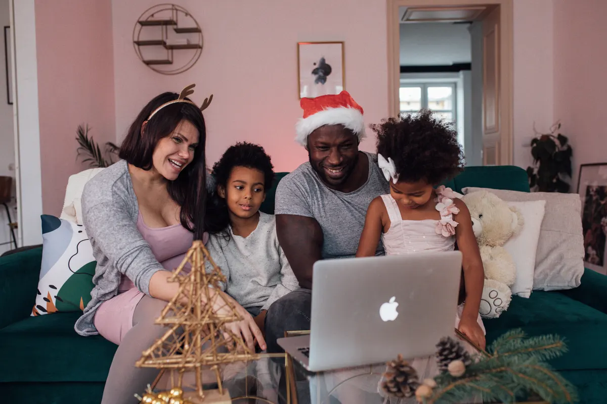 Mehrere Generationen planen Weihnachtsgeschenke gemeinsam am Laptop