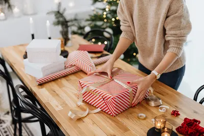 Person verpackt ein reserviertes Geschenk aus einer Wunschliste Person verpackt ein reserviertes Geschenk aus einer Wunschliste