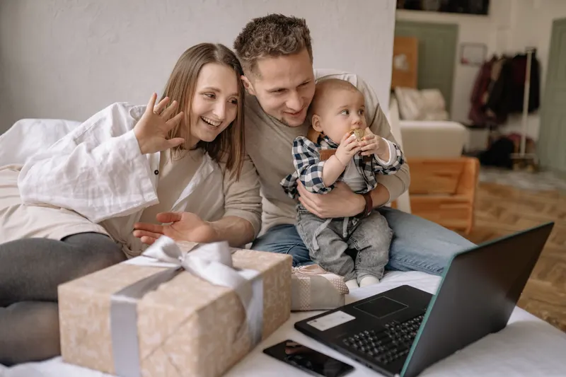 Eltern stellen gemeinsam eine Tauf-Wunschliste am Laptop zusammen Eltern stellen gemeinsam eine Tauf-Wunschliste am Laptop zusammen