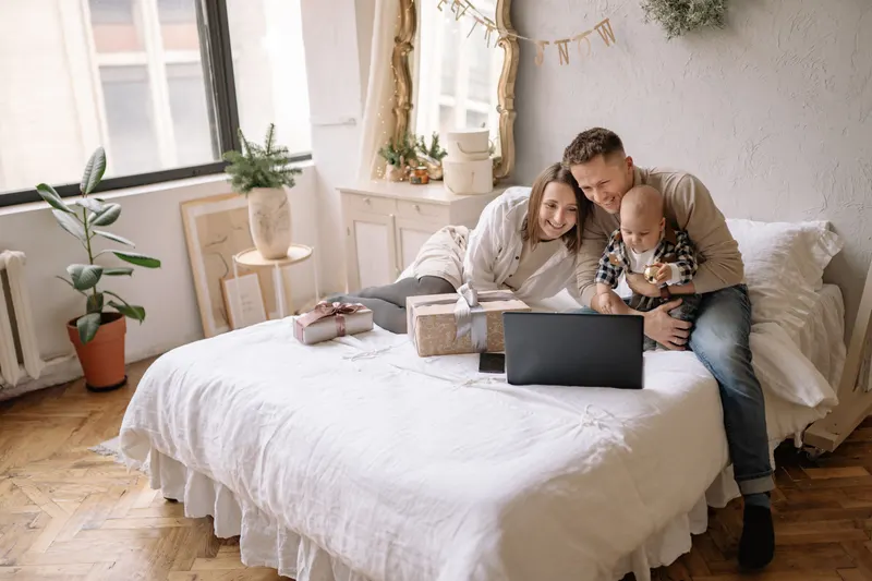 Familie plant Geschenke gemeinsam am Laptop Familie plant Geschenke gemeinsam am Laptop