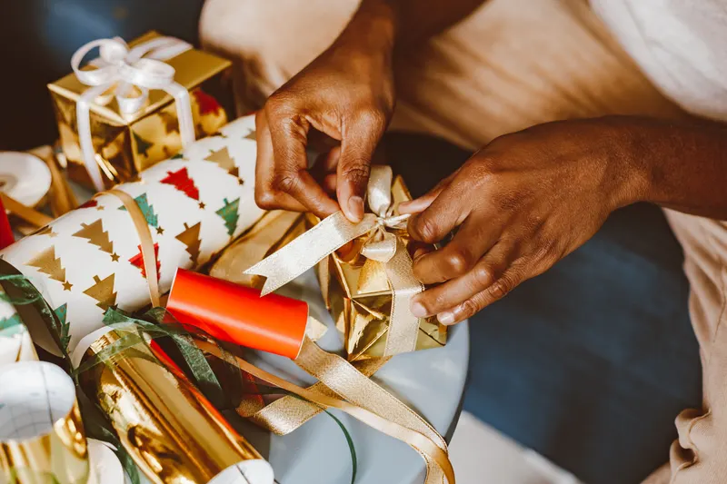 Person verpackt ein Geschenk für die Familie Person verpackt ein Geschenk für die Familie