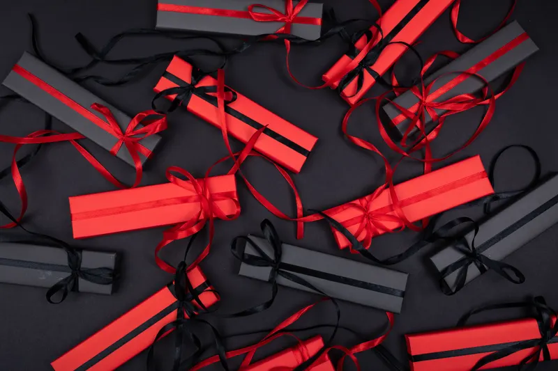 Person verpackt ein Geschenk zur Firmung mit Geschenkpapier Person verpackt ein Geschenk zur Firmung mit Geschenkpapier