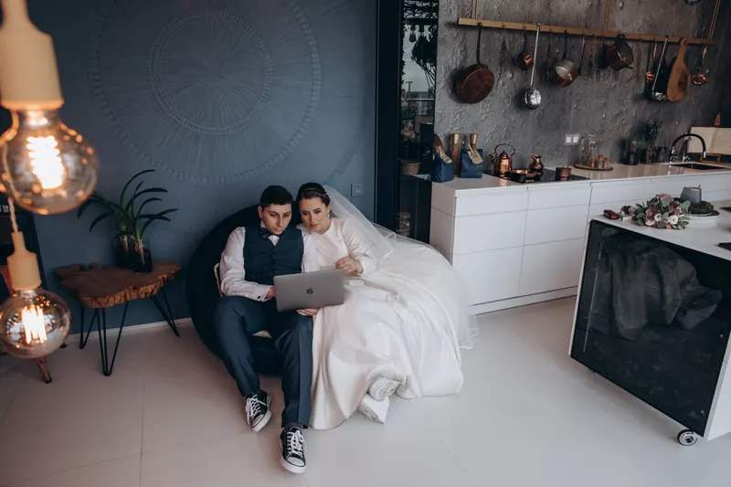 Paar stellt gemeinsam die Hochzeitswunschliste am Laptop zusammen Paar stellt gemeinsam die Hochzeitswunschliste am Laptop zusammen