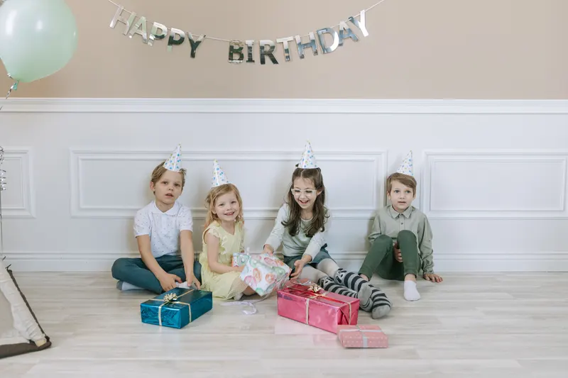 Kinder freuen sich über gemeinsame Geschenke bei einer Feier Kinder freuen sich über gemeinsame Geschenke bei einer Feier