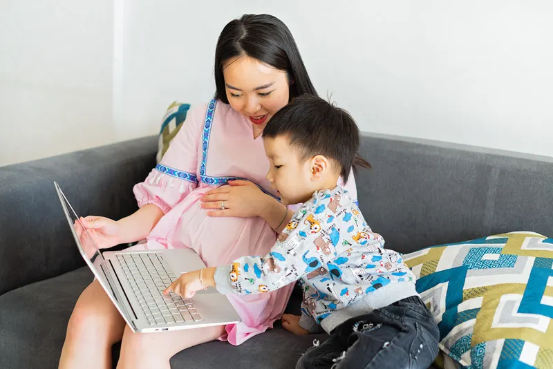 Kind und Eltern stellen gemeinsam eine Wunschliste am Laptop zusammen Kind und Eltern stellen gemeinsam eine Wunschliste am Laptop zusammen