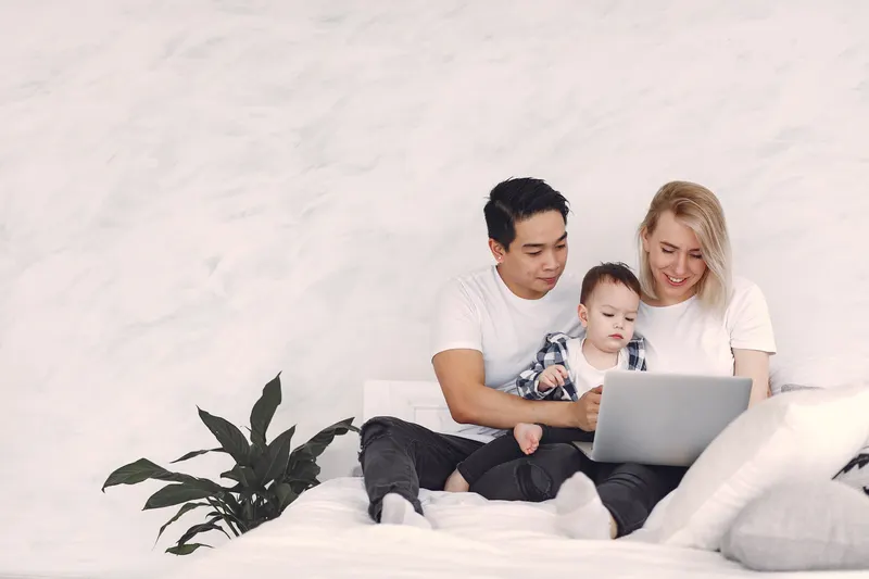 Eltern und Kind stellen gemeinsam eine Kommunion-Wunschliste am Laptop zusammen Eltern und Kind stellen gemeinsam eine Kommunion-Wunschliste am Laptop zusammen