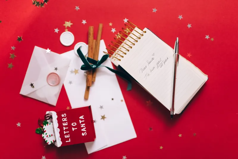Jemand schreibt Weihnachtswünsche in ein Notizbuch Jemand schreibt Weihnachtswünsche in ein Notizbuch