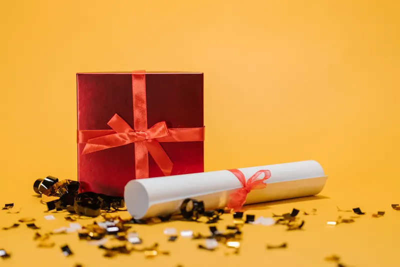 Person verpackt ein Geschenk zur Einschulung mit Geschenkpapier Person verpackt ein Geschenk zur Einschulung mit Geschenkpapier