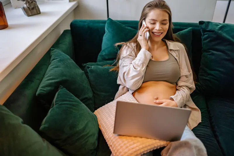 Werdende Eltern planen die Baby-Erstausstattung am Laptop Werdende Eltern planen die Baby-Erstausstattung am Laptop